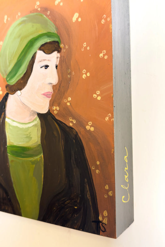 Painting of a woman with a green headscarf and green dress on an orange background, signed 'Clara'. by artist Teri Stephens