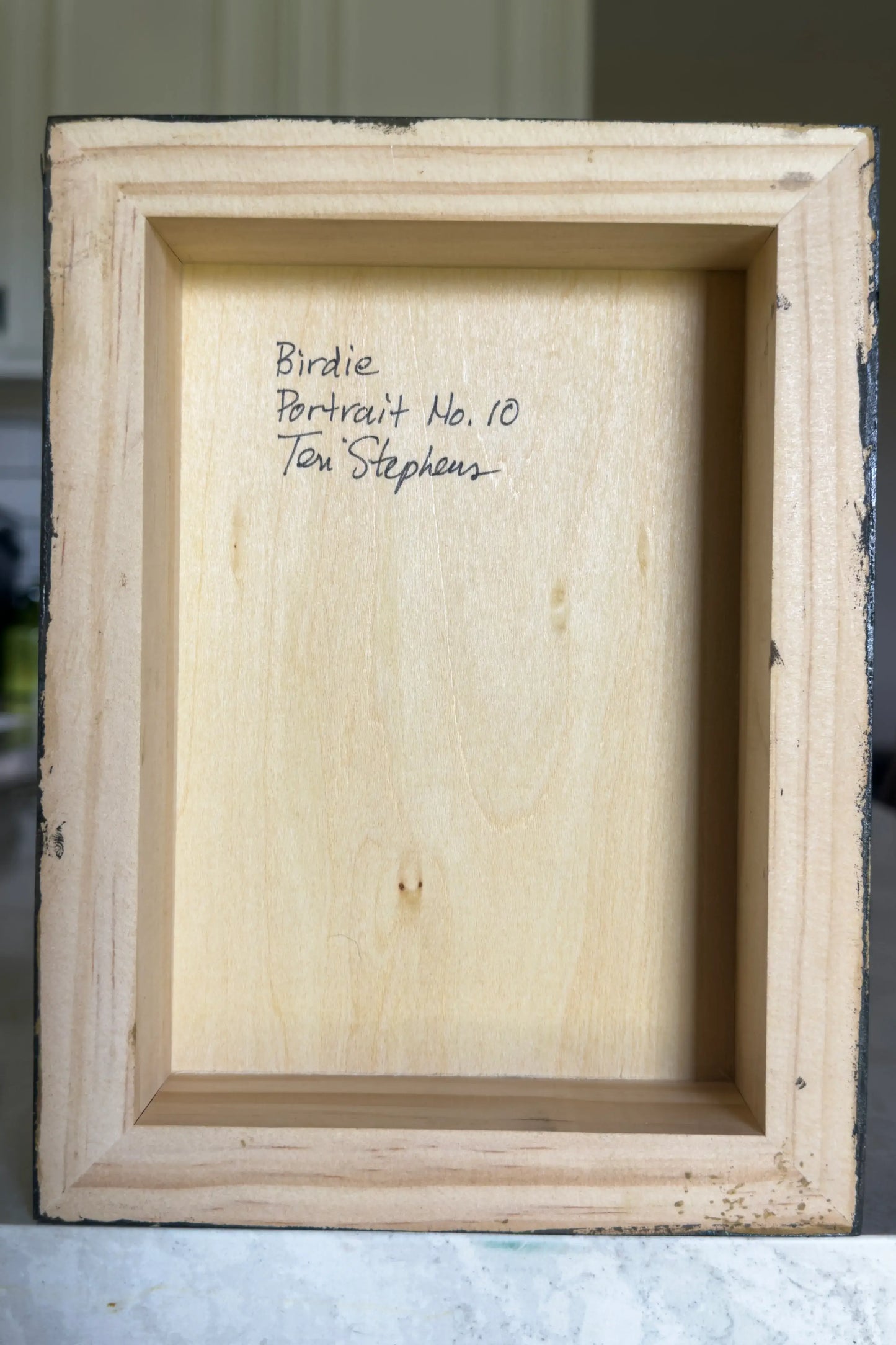 Wooden picture frame with text on a neutral background