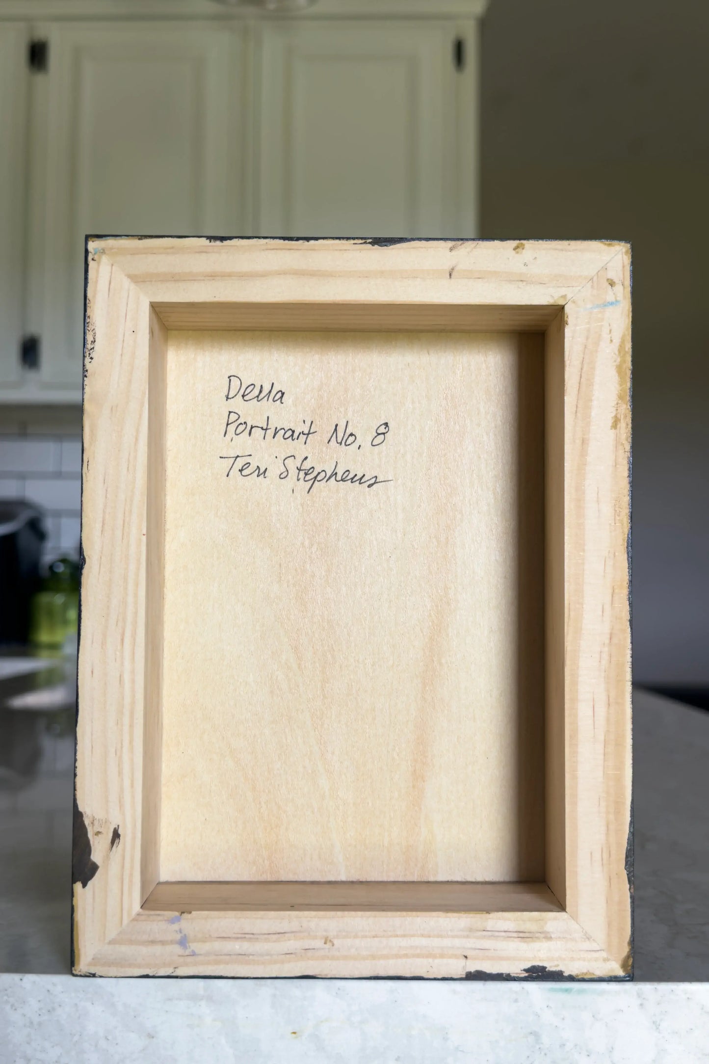 back view of a painting on wood panel with artist signature