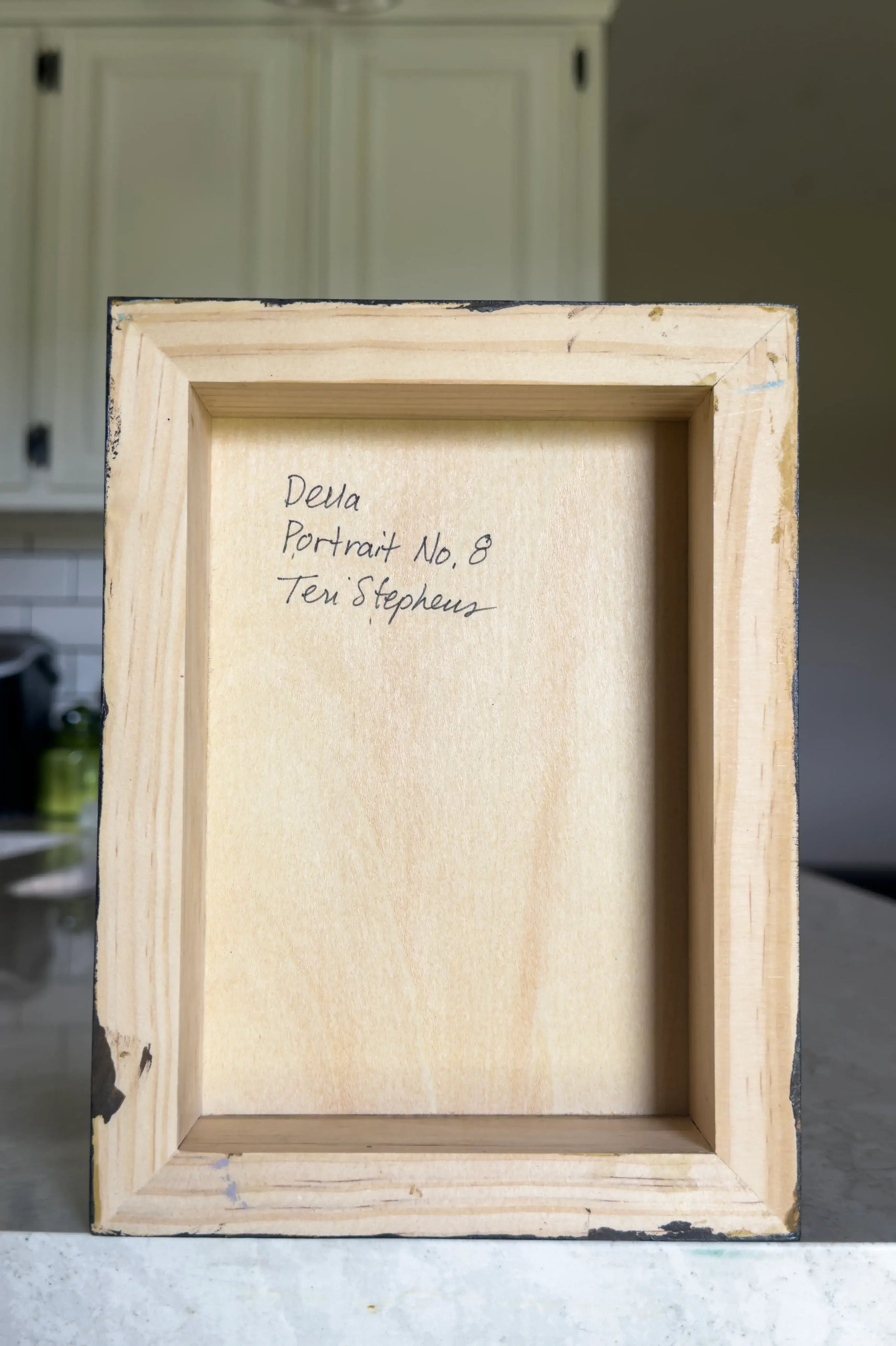 back view of a painting on wood panel with artist signature