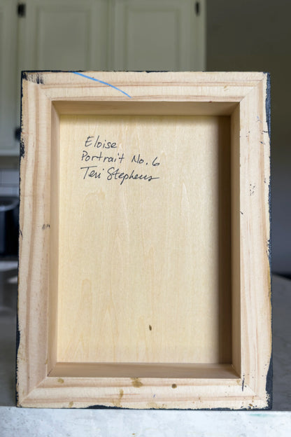 Back of a wooden picture frame with text on a neutral background
