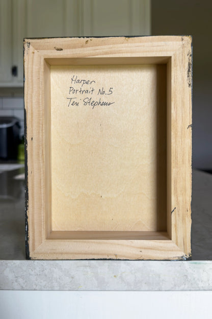 Back of a wooden frame with text on a neutral background