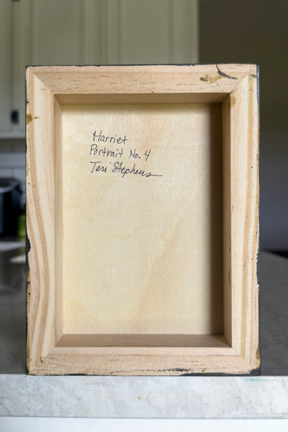 Back of a wooden picture frame with text on a marble surface