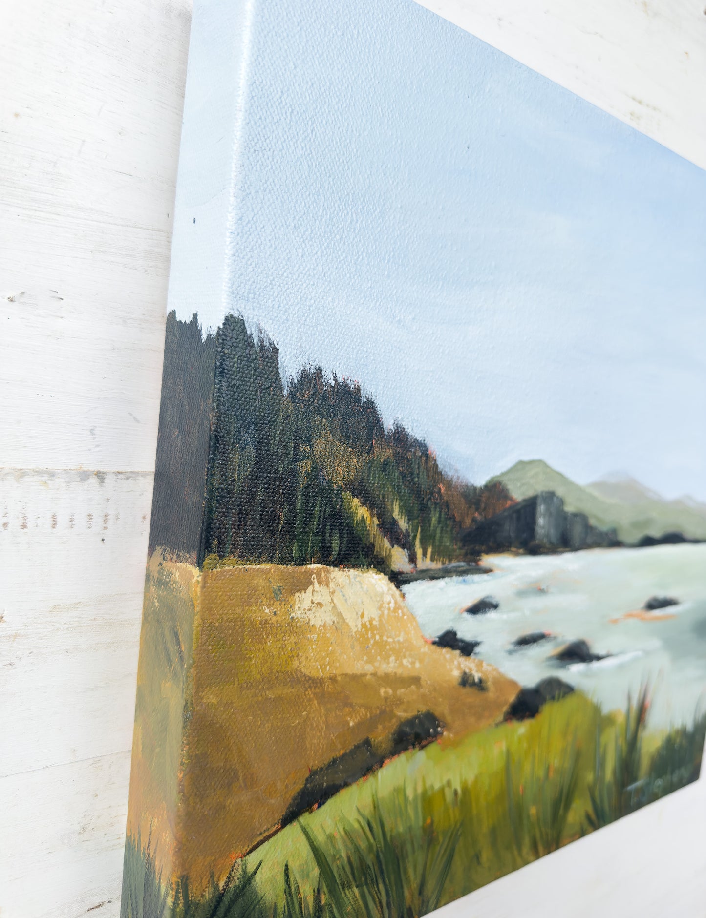 Painting of a landscape with trees, field, and mountains on a textured surface. original painting titled "Headland" by Teri Stephens