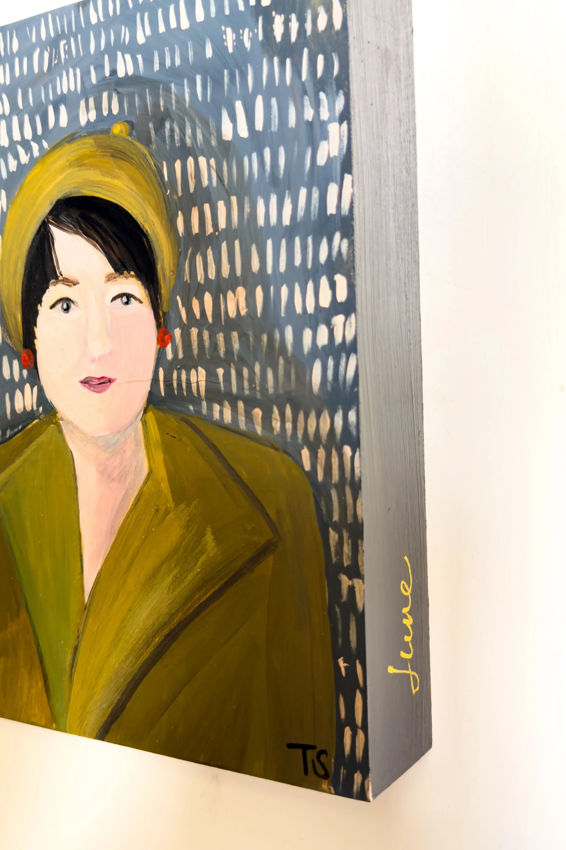 Painting of a woman wearing a green coat and yellow hat against a patterned background
