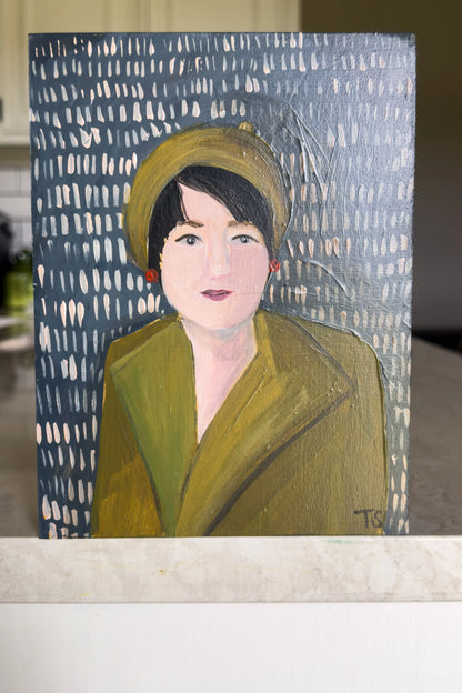 Painting of a woman wearing a green coat and hat on a blue and white patterned background. "June" by artist Teri Stephens