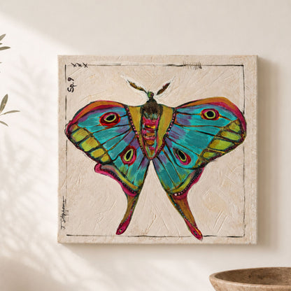 Kismet is an original painting of a luna moth, styled in bold colors of blue, teal, green and pink. 