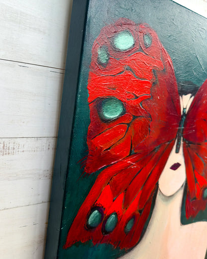 Painting of a red butterfly with green spots on a black background