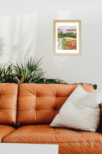 Framed artwork titled Path by artist Teri Stephens, above an orange leather sofa with a plant in the corner.