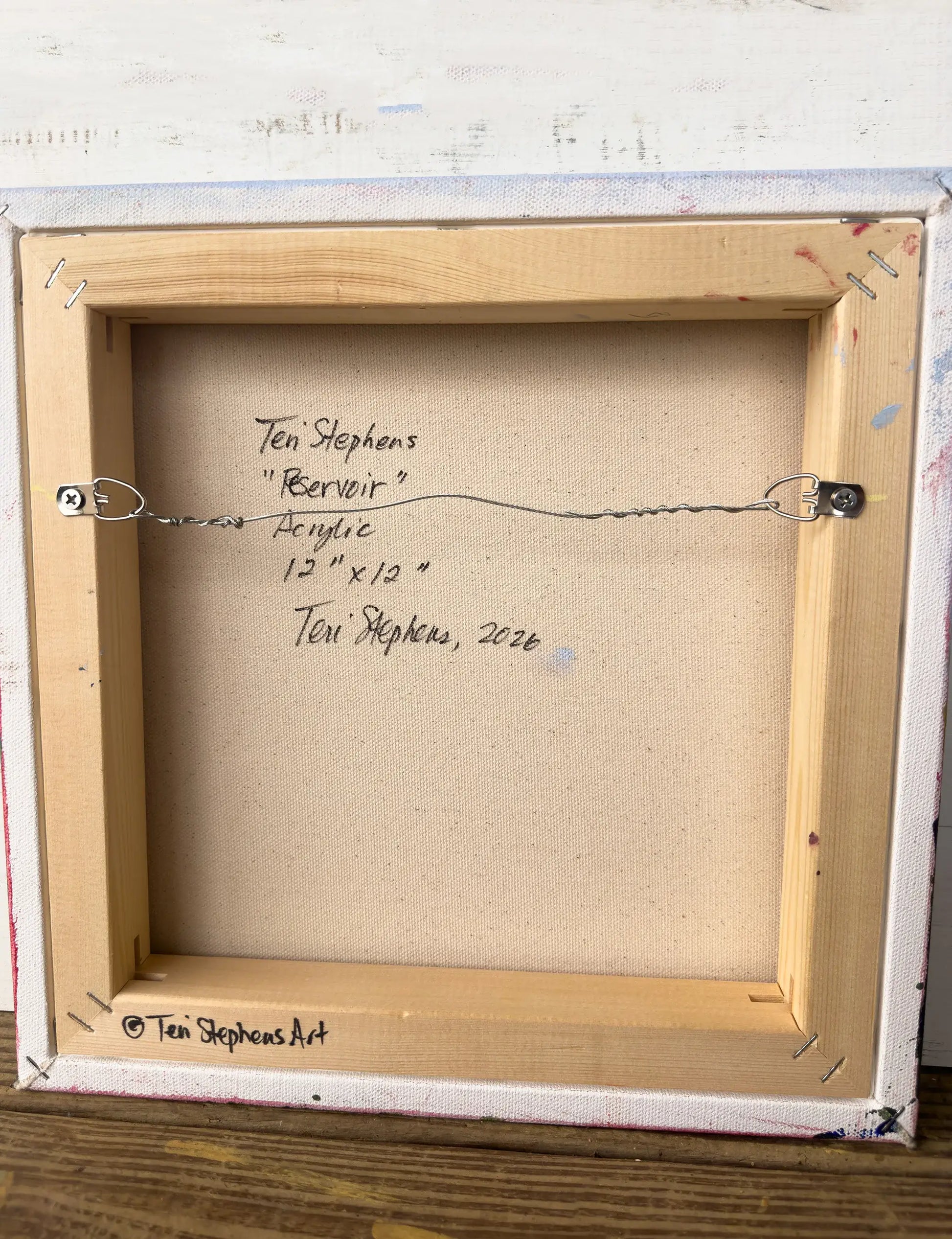 Back of a framed painting with artist's signature and details,  original painting titled "Reservoir" by Teri Stephens