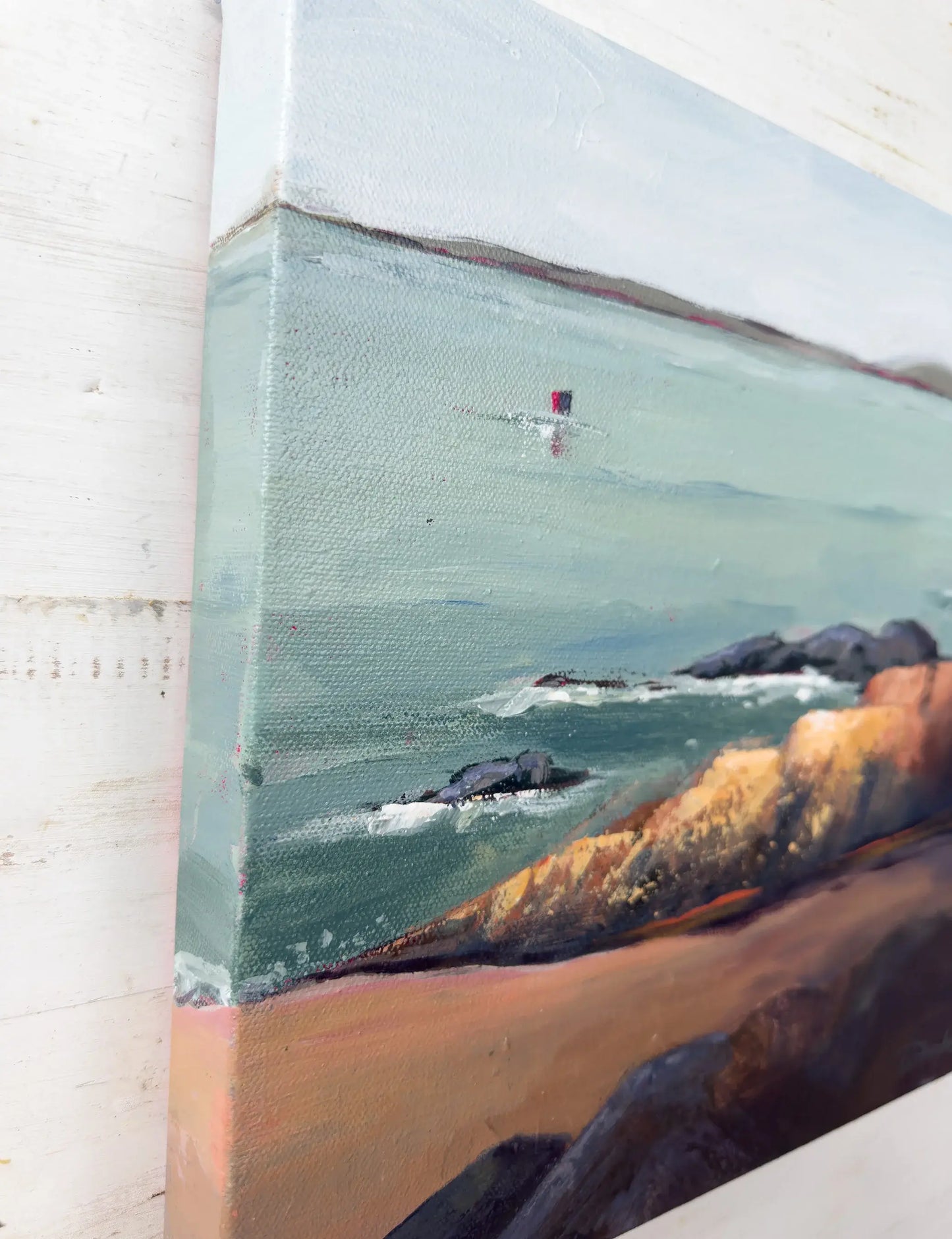 Close-up of a painting of a coastal scene with rocks and water. Original artwork titled "Rock" by Teri Stephens.