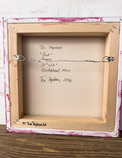 Back of a framed artwork with signature and details on a wooden surface, Original artwork titled "Rock" by Teri Stephens.
