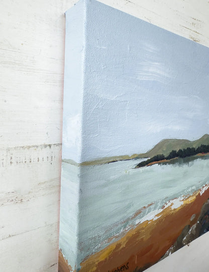 Canvas painting of a landscape with a blue sky, green trees, and brown earth. Angled view of "Shore" by Teri Stephens