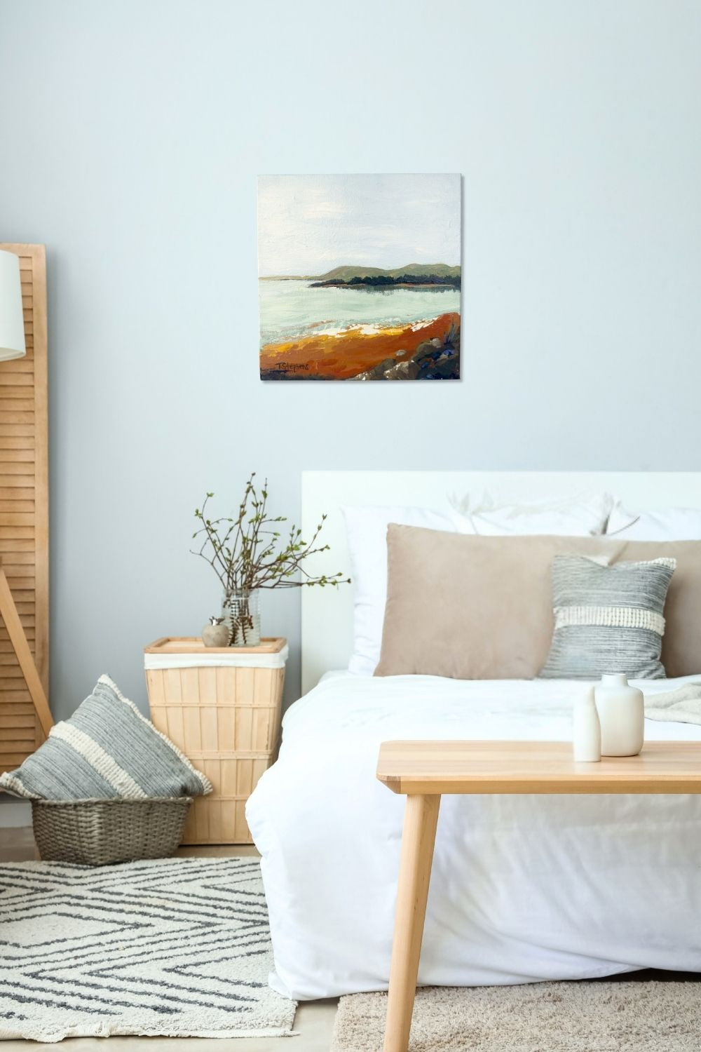 Living room with a bed, table, and abstract painting on the wall titled "Shore" by Teri Stephens.