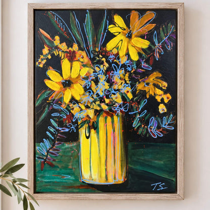 A framed painting of a vibrant yellow flower bouquet in a striped yellow vase against a dark background, displayed on a light beige wall with a small green plant leaf in the foreground.
